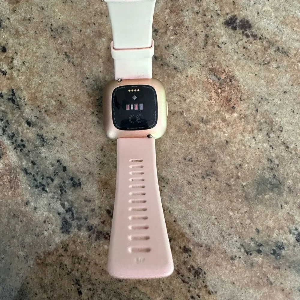 Fitbit versa with pink band and charger